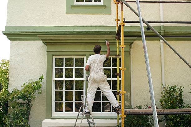 Professional painter applying fresh coat of paint to a wall